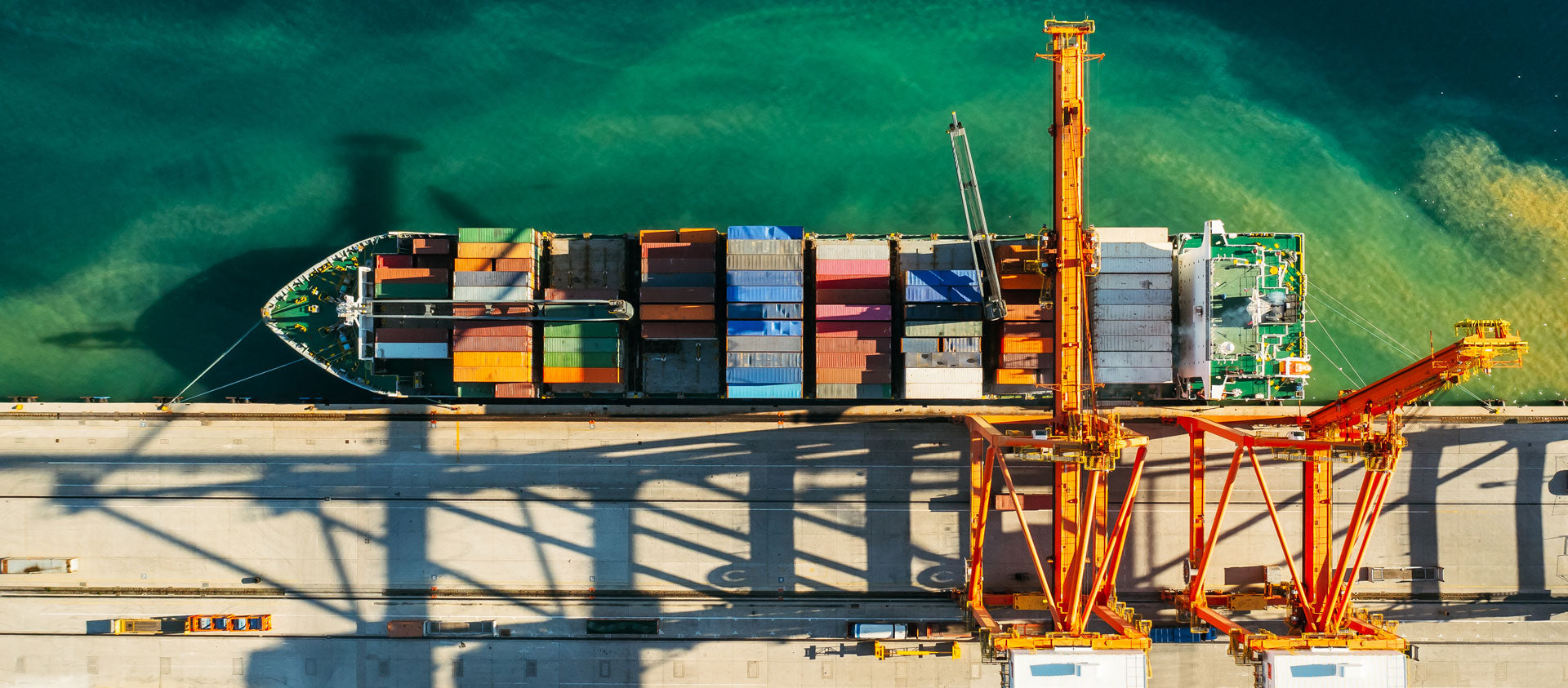 Ein Schiff wird mit Kränen in einem Logistik-Hafen beladen